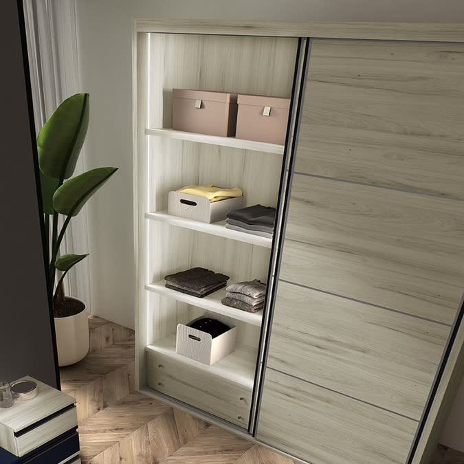 Detalle de armario de puertas correderas en madera clara con estantes interiores