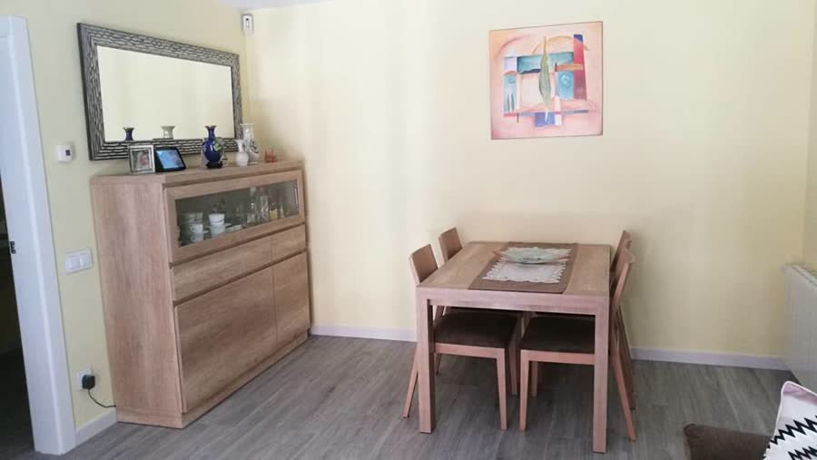 Salón con sofá y mueble para televisor en madera clara