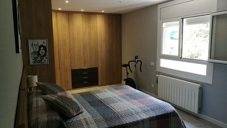 Dormitorio con armario grande y cama en madera
