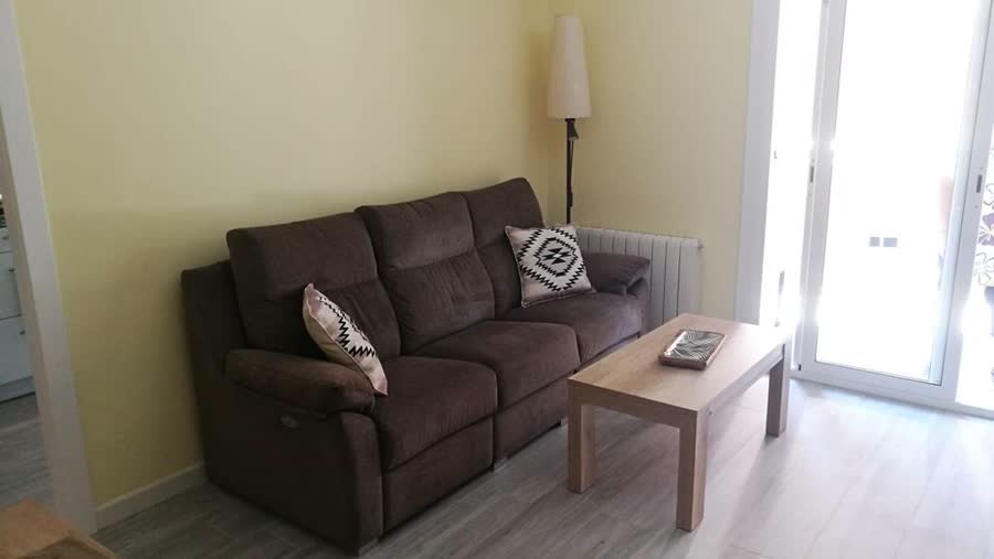 Salón con sofá marrón y mesa baja, con paredes amarillas