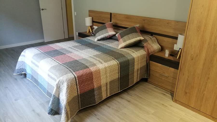 Dormitorio con cama y armario en madera