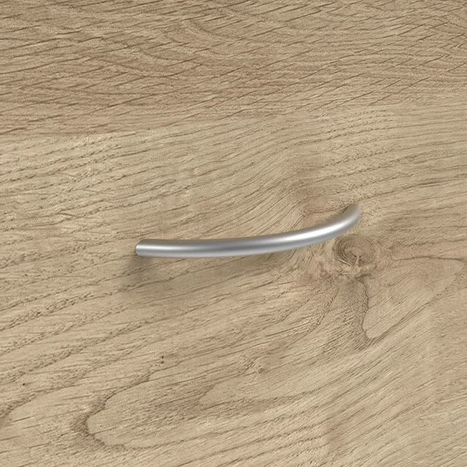 Detalle de tirador curvo metálico sobre madera
