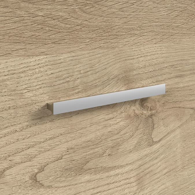 Detalle de tirador de barra metálica sobre madera